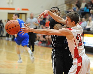 HOWLAND, OHIO - MARCH 25, 2014: Brandon Bates #21 of Badger reaches for the ball after poking it out of the control of Terrell McClain #20 of East during Tuesday nights Frank Bubba Classic boys basketball all-star game at Howland High School.