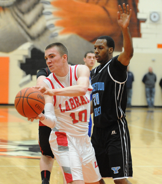 HOWLAND, OHIO - MARCH 25, 2014: Peyton Aldridge #10 of Labrae looks to pass the ball after dribbling into the paint and Terrell McClain of East was guarding during Tuesday nights Frank Bubba Classic boys basketball all-star game at Howland High School.