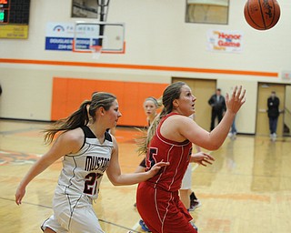 HOWLAND, OHIO - MARCH 25, 2014: Cassie Cluster #15 of Fitch tracks down the loose ball while being pressured by Dayna Ellis #25 of Mathews during the second half of Tuesday nights Frank Bubba Classic girls basketball all-star game at Howland High School. Mahoning County won 67-62.