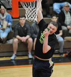 HOWLAND, OHIO - MARCH 25, 2014: Seth Wallace of Brookfield takes a selfie on his cell phone while slam dunking the basketball before of Tuesday nights Frank Bubba Classic boys basketball all-star game at Howland High School.