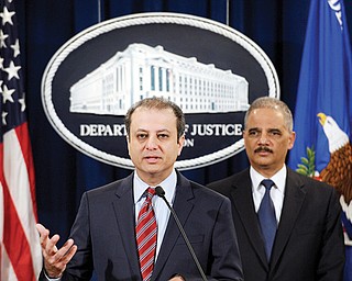 Attorney General Eric Holder listens at right as U.S. Attorney for the Southern District Preet Bharara talks about the $1.2 billion settlement with Toyota over its disclosure of safety problems during a news conference at the Justice Department in Washington.