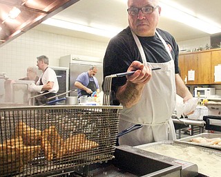 Dean Paidas of St. John the Forerunner Greek Orthodox Church makes sure fried fish is done to perfection at the Seafood Fest. He is among the 40 to 50 church members who volunteer at the Lenten project. The fest is Fridays through April 11.