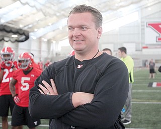 Youngstown State head football coach Eric Wolford watches Tuesday’s practice at YSU’s WATTS. Wolford will be overseeing the team for an additional two years once the details of his contract extension are ironed out.