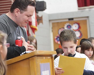 Jason Cooke, left, president of Animal Charity Humane Society, listens to Shamus Clavin , a second-grader at West Boulevard Elementary School in Boardman, as the youngster reads his winning essay at an awards ceremony. The school and Animal Charity have teamed up to help children make a difference in their community.
The event was Wednesday.