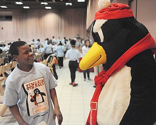 Harding Elementary School student Martize Daniels hangs out Thursday with Pete the Penguin during the Penguin Pen Pals get-together at Youngstown State University. Students from YSU and Harding wrote to each other throughout the school year and met Thursday.