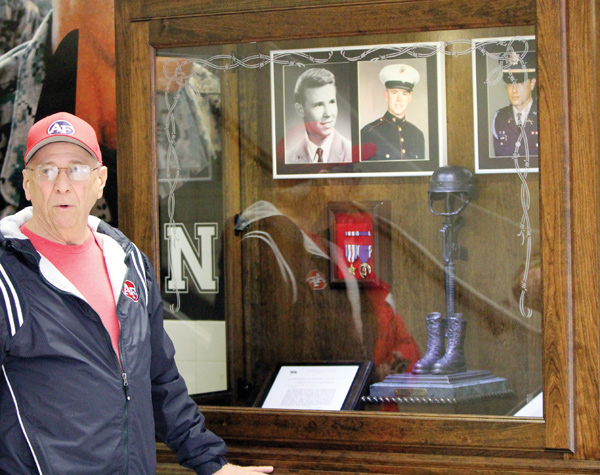 Jack Kidd, a member of the Austintown Class of 1962 Veterans’ Memorial Committee, stands in front of a display at Fitch High School that honors two 1962 graduates who were killed in action in Vietnam.