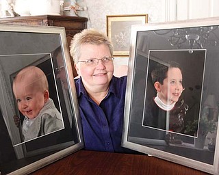 Patty McCauley Guarnieri of Boardman poses with photographs of her grandsons, 10-month-old Cole Muir and 6-year-old Luke Lantz. Guarnieri has been battling advanced kidney cancer for almost 24 years.