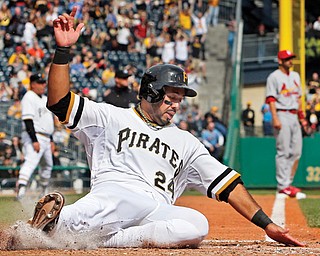 Pirates baserunner Pedro Alvarez scores on a double by Tony Sanchez off Cardinals starting pitcher Adam Wainwright during the seventh inning of Sunday’s game at PNC Park in Pittsburgh. The Pirates won 2-1.