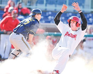 YSU’s Phil Lipari, right, slides home safely as Kent State catcher Jeff Revesz (27) tries to handle a throw during the
first game of a doubleheader at Eastwood Field in Niles. KSU won the first game, 11-7, but YSU took the second, 7-4.