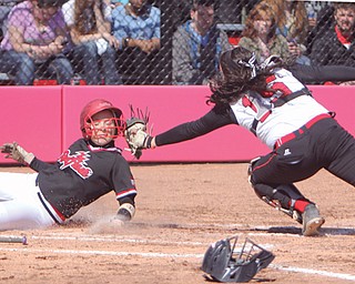 Saint Francis’ Aly Ramsaier is tagged on the helmet by Youngstown State catcher Maria Lacatena but she is safe at home during Game 1 of their softball doubleheader Wednesday at the YSU softball complex. The teams split, with the Red Flash winning the first game 6-3 and the Penguins winning Game 2, 4-3.
