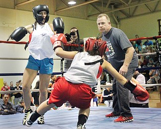 Referee Jack Loew watches as East Palestine’s Hailey Hall knocks down Nicole Rodriguez of Youngstown Christian during their flyweight bout in the K.O. Drugs High School Boxing Tournament championship Thursday in North Lima. Hall won by unanimous decision.