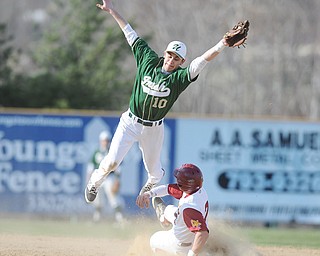 Ursuline’s Bobby Dulay leaps over Cardinal Mooney’s Drew Wollett as Wollett steals second during a game Thursday at Cene Park in Struthers. The Cardinals edged the Irish, 8-6.