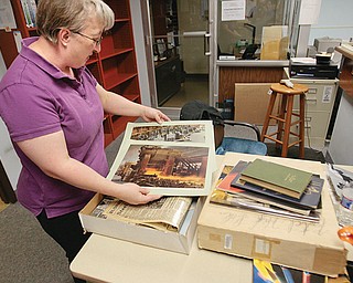 Sheila Henline, substitute librarian at Fitch High School, looks at old steel mill photos that were found as she tackled the task of removing old books.