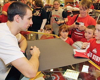 Former Ohio State University basketball player Aaron Craft, left, talks basketball with Cody Cope, 10, far right, and his siblings, from left, McKenzie, 5, Madie, 9, and Chance, 7, on Sunday during an appearance at the Everything Buckeyes store at Eastwood Mall in Niles.