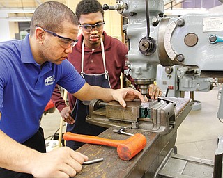 Josh Abell of Youngstown Christian High School and Jo’Nathan Russ, a student at Summit Academy High School, use a drill in the precision machining program at Choffin Career and Technical Center in Youngstown. The course teaches students how to read blueprints and to safely operate and program a variety of advanced machines to manufacture parts with precision.