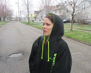 Heather Long of Warren stands on High Street Northeast near the Warren Greenway bike trail Tuesday. Her 14-year-old son was assaulted and robbed of his possessions and his clothes on the bike trail Monday. Police are investigating.