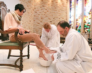 The Rev. Jeff Baker, right, rector at Christ Episcopal Church in Warren, demonstrates the foot-washing ritual that will be carried out today, Maundy Thursday, at a service at 7 p.m. Joan Seaver, chalice bearer, assists with the ritual as Melanie Garman, church secretary, has her feet washed.