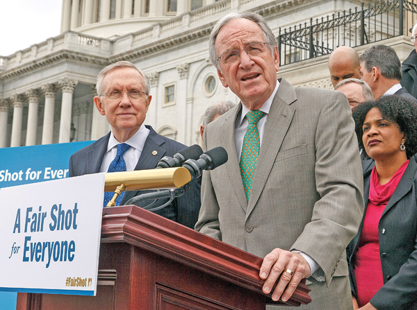 Senate Health, Education, Labor and Pensions Committee Chairman Sen. Tom Harkin, D-Iowa, at podium, accompanied by Senate Majority Leader Harry Reid of Nevada, left, and others, urges approval for raising the minimum wage, during a news conference on Capitol Hill in Washington.
