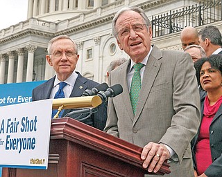 Senate Health, Education, Labor and Pensions Committee Chairman Sen. Tom Harkin, D-Iowa, at podium, accompanied by Senate Majority Leader Harry Reid of Nevada, left, and others, urges approval for raising the minimum wage, during a news conference on Capitol Hill in Washington.