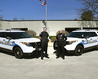 Liberty police officers Michael Shuster, left, and Robert Altier have new rides. The township bought two 2014 Ford Explorers, which went on the road Wednesday. The SUVs were bought with confi scated drug money.