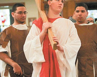 Jesus, played by Jacob Sebest, 17, of Campbell, carries the cross while being whipped by guards, Jan-carlos Lebron, 17, left, and Christian Nieves, 15, during a rehearsal for live Stations of the Cross at St. John the Baptist Church in Campbell. The event will be at 1 today.