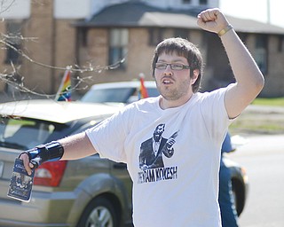 Jakub Kelly, 20, of Youngstown, walks down the sidewalk along Wick Park on Sunday reciting a chant about marijuana legalization. About 20 people attended the rally.