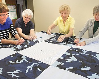 Working on a quilt at Lord of Life Lutheran Church in Canfield are from left: Barb Loitwood, Diana Williams,
Doris Puerner and Mary Lou Drotleff. The group makes about 75 quilts per year and donates them to a world-relief organization.