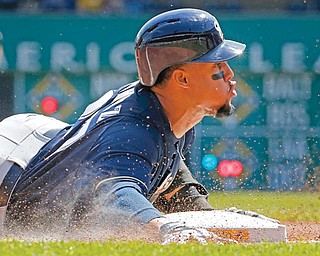 Brewers baserunner Carlos Gomez slides into third with a triple during the third inning of a Sunday’s game against the Pirates in Pittsburgh.