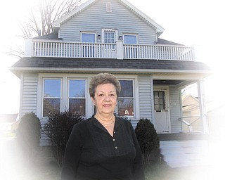 Lena Pilgrim stands in front of her home at 675 Perkinswood Blvd. SE, Warren, which is where rock drummer Dave Grohl and his family lived in 1969, when Grohl was born.