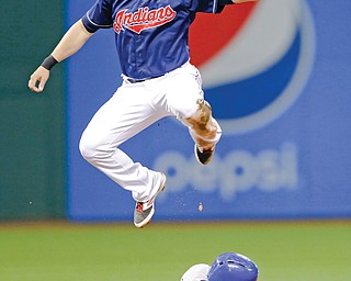 Indians shortstop Asdrubal Cabrera leaps over the Royals’ Alcides Escobar (2), who stole second base in
the fourth inning of a game Tuesday night at Progressive Field in Cleveland. Escobar went to third as the high throw went into center field.