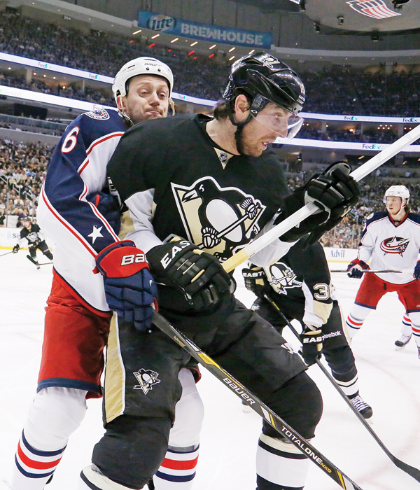 Pittsburgh Penguins’ James Neal (18) battles Columbus Blue Jackets’ Nikita Nikitin (6) for the puck in the corner in the second period of Game 5 in Pittsburgh on Saturday. The Penguins won 3-1.