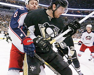 Pittsburgh Penguins’ James Neal (18) battles Columbus Blue Jackets’ Nikita Nikitin (6) for the puck in the corner in the second period of Game 5 in Pittsburgh on Saturday. The Penguins won 3-1.