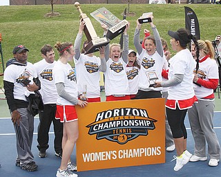 Members of Youngstown State’s women’s tennis team hold up their Horizon League championship trophies
following Sunday’s match in Ann Arbor, Mich. The Penguins defeated Cleveland State 4-2 in the final.