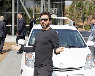 Google co-founder Sergey Brin gestures after riding with officials in a driverless car to a bill-signing for driverless cars at Google headquarters in Mountain View, Calif.
