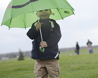 Katie Rickman | The Vindicator.Anthony Miller, 3, of Austintown hides under his frog umbrella after flying kites in the rain at the Youngstown MetroParks Farm in Canfield May 3, 2014.