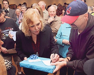 Bob Simmons, right, of Youngstown gives a gift to Kim Novak during a reception at the Butler Institute of American Art in Youngstown on Sunday afternoon. The film legend’s art exhibition runs through June 29.