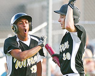 Warren Harding’s Adam Butler, left, celebrates with teammate Marcus Masters after scoring the tying run in
the seventh inning of their Division I sectional semifinal against Boardman on Tuesday in Boardman. The Raiders rallied in the seventh, scoring three runs to oust the Spartans, 3-2.