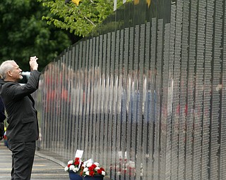        ROBERT K. YOSAY  | THE VINDICATOR..Michael Glonik of Andover and YSU takes a photo of some of the names on the wall..YSU - "the Reading of the Name" an annual service to honor the YSU students and faculty that lost their lives in service to the country was combined this year with the The American Veterans Traveling Tribute/Vietnam Traveling Wall -Wednesday through Sunday...The 360-foot-long wall, an 80-percent scale version of the Vietnam Memorial Wall in Washington, D.C., will be open for viewing round-the-clock in the parking lot on Wood Street at YSU..-..                    -30-