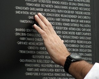        ROBERT K. YOSAY  | THE VINDICATOR..a hand reads the names on the wall..YSU - "the Reading of the Name" an annual service to honor the YSU students and faculty that lost their lives in service to the country was combined this year with the The American Veterans Traveling Tribute/Vietnam Traveling Wall -Wednesday through Sunday...The 360-foot-long wall, an 80-percent scale version of the Vietnam Memorial Wall in Washington, D.C., will be open for viewing round-the-clock in the parking lot on Wood Street at YSU..-..                    -30-