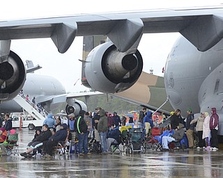 Katie Rickman | The Vindicator.Viewers of Thunder Over the Valley take shelter under the wing of a plane May 17, 2014. Many of the flights were canceled due to weather restrictions.