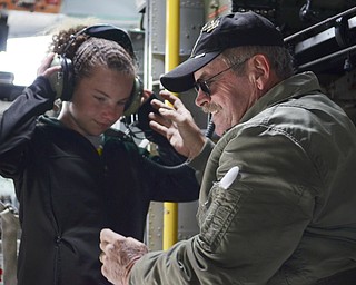 Katie Rickman | The Vindicator.Bob Gbur of East Palestine places headphones on Santina Masters, 10 of Hermitage, PA in the legendary Thunder Pig aircraft at Thunder Over the Valley May 17, 2014.