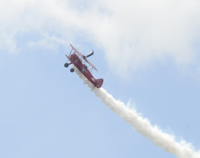 Katie Rickman | The Vindicator.Third Strike Wingwalking flies during Thunder Over the Valley May 18, 2014.  Pilot Marcus Ping flies as wing walker Carol Pilon stands on top of the plane as it flies.