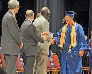 James Copeland, far right, shakes hands with school administrators during the Youngstown Early College’s commencement ceremonies at the DeYor Performing Arts Center on Sunday. Copeland, 18, was president of YEC’s Class of 2014 and will attend Ohio State University in the fall on a full academic scholarship.