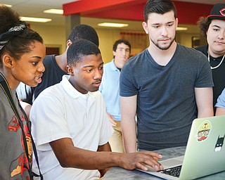 Chaney High School students, from left, Breona Taylor and De’Ondre Walker, Drund software engineer Mike Helmick and student Jason Carlo review the application the students created during the Chaney Code Academy.