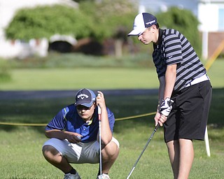 Katie Rickman | The Vindicator.Vince Goleno, 17, of Austintown (left) watches as Alec Hamilton, 15, also of Austintown putts during the Greatest Golfer Junior Qualifiers May 24, 2014.
