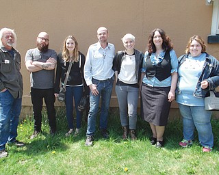 Posing for a photograph in front of the blank wall that will soon be covered with a mural depicting life throughout the decades in the Youngstown Sheet & Tube Co. worker housing complex in Campbell are, from left, David Donofrio, Clayton Donofrio, Marcy Gussenhofen , Tim Sokoloff , Katelyn Gould, Linda Gens and April Caruso-Richards. Gould, a Pittsburgh-based artist, will paint the mural, and be assisted by Gussenhofen. Sokoloff , Gens and Caruso-Richards are the Iron Soup Historical Preservation Co.’s president and chairman, executive director and board secretary, respectively.