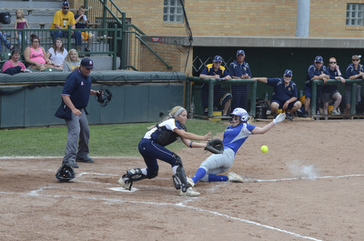Katie Rickman | The Vindicator.Poland's Taylor Miokovic (no. 15) slides in safe and scores the only point for Poland during the tournament against Tallmadge in Akron May 28, 2014. Catcher Tori Young (no. 21) stands on home plate in attempt to tag her out.