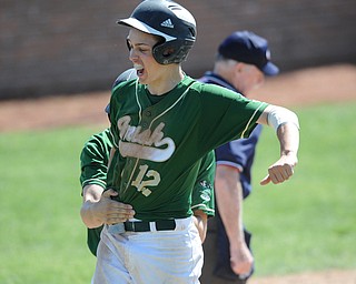 MASSILLON, OHIO - MAY 29, 2014: Base runner Gianni Quattro #12 celebrates after scoring the 6th and go-ahead run of the game, while being grabbed by teammate John Hintz #7 during a OHSAA tournament game at Massillon Washington High School. Ursuline won 7-5. (Photo by David Dermer/Youngstown Vindicator)