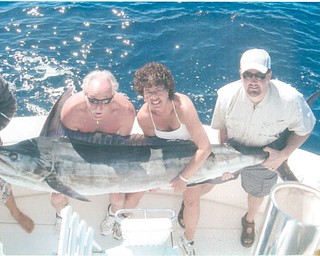 Denise Houser caught this 200-pound blue marlin in 2006, while deep-sea fishing in Cabo San Lucas. On the left is her husband, Gary, and on the right is Chris Herubin, a friend. All are from Boardman.