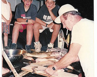 July 25, 1992, Grandpa, Loren Burns, shows three of his grandsons Bobby Hutchko, left, Richard Burns, and Brad Burns how to filet fish he had caught earlier that day.